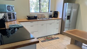 Eine kompakte Küche mit Mikrowelle, Toaster, Kaffeemaschine und Kühlschrank.