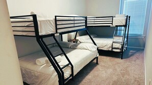 A room with bunk beds, carpeted floor, and a window with blinds. - Stylish Family Townhouse in Baton Rouge LA- BC1004 (Baton Rouge)