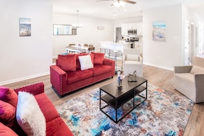 A modern living room with a red sofa, a coffee table, and a colorful rug.