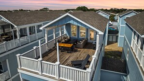 A multi-story residential building with a deck and outdoor seating area. - Spring Break, Sunset Deck, Gameroom, 1 block to beach, Sleeps 17, gas grill (Panama City Beach)