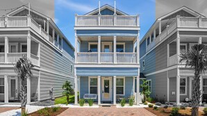 A two-story beachfront building with a balcony, a brick pathway, and a small garden area. - Spring Break, Sunset Deck, Gameroom, 1 block to beach, Sleeps 17, gas grill (Panama City Beach)