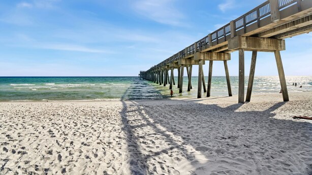A beach with a pier extending into the ocean. - Spring Break, Sunset Deck, Gameroom, 1 block to beach, Sleeps 17, gas grill (Panama City Beach)