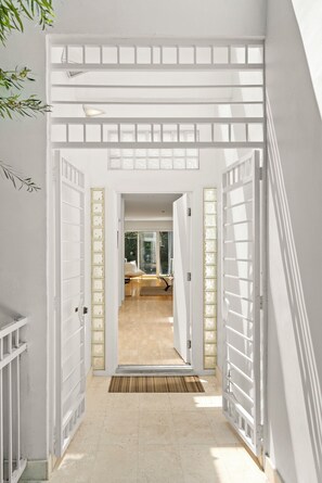 Stylish corridors lead to bedrooms with a bed and window.