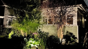 Ein zweistöckiges Haus mit einer sichtbaren Haustür und einer kleinen Veranda.