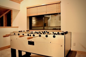 A foosball table in a room with a window and wooden blinds. - Modern Tahoe cabin: A/C, ping pong, EV charge, family friendly, work trips (Truckee)