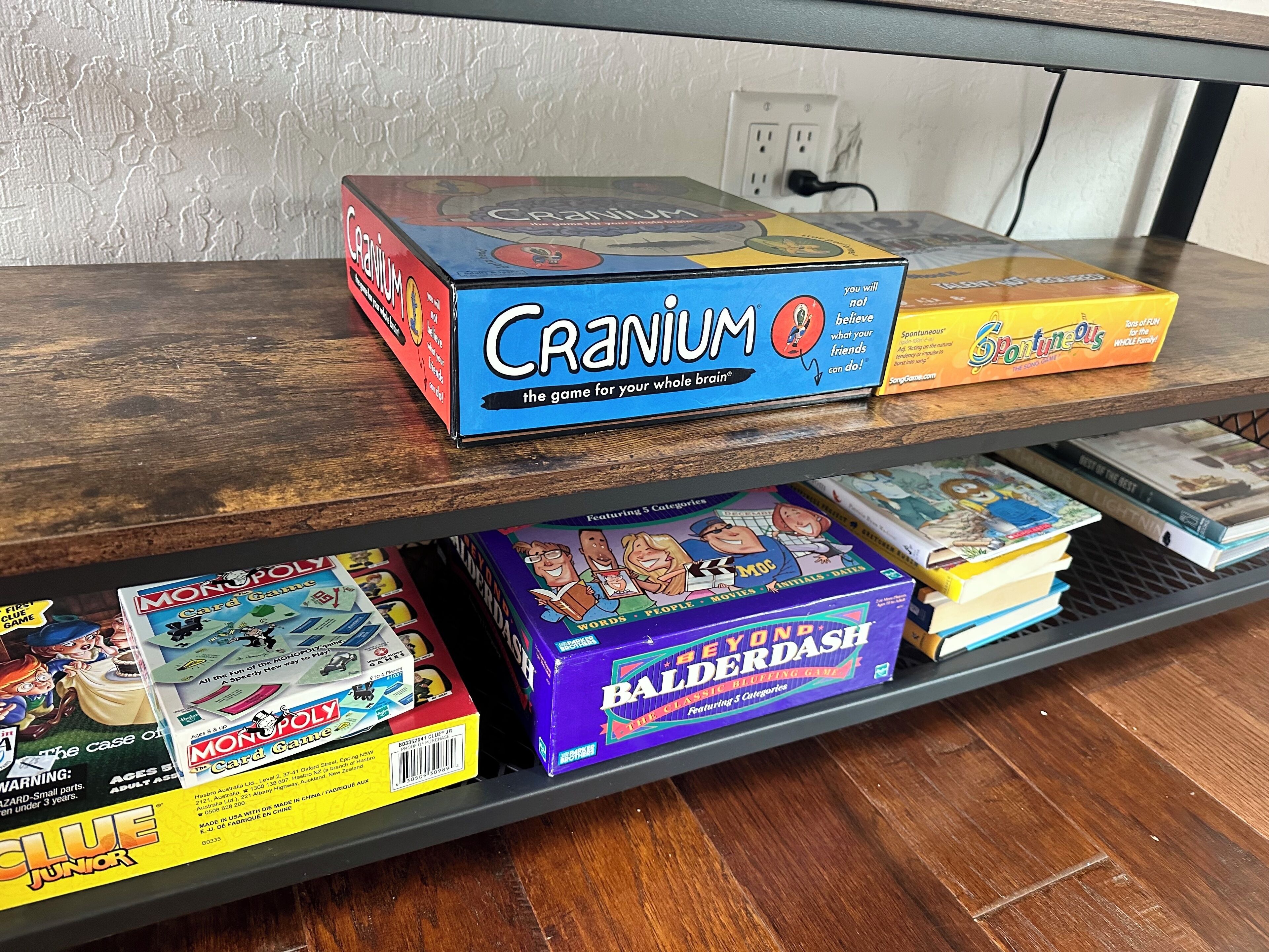 A shelf with various board games including 'Cranium' and 'Monopoly'.