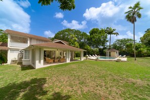 Une maison à deux étages dotée d’un patio couvert, d’une piscine et d’un belvédère.