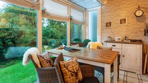 Un comedor con una mesa, sillas y vistas al jardín.