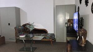 Ein Wohnzimmer mit einer Couch, einem Couchtisch und einem Fernseher.