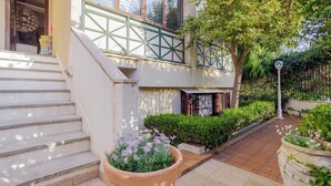 Un edificio residencial con una escalera, una puerta, una ventana y una planta en maceta.