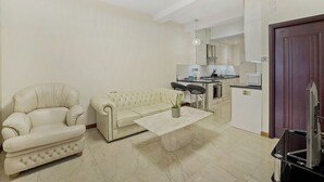 A living room with a sofa, a coffee table, and a television. - Luxury Oceana Apartment, Central City Centre, Newly Refurbished (Plymouth)