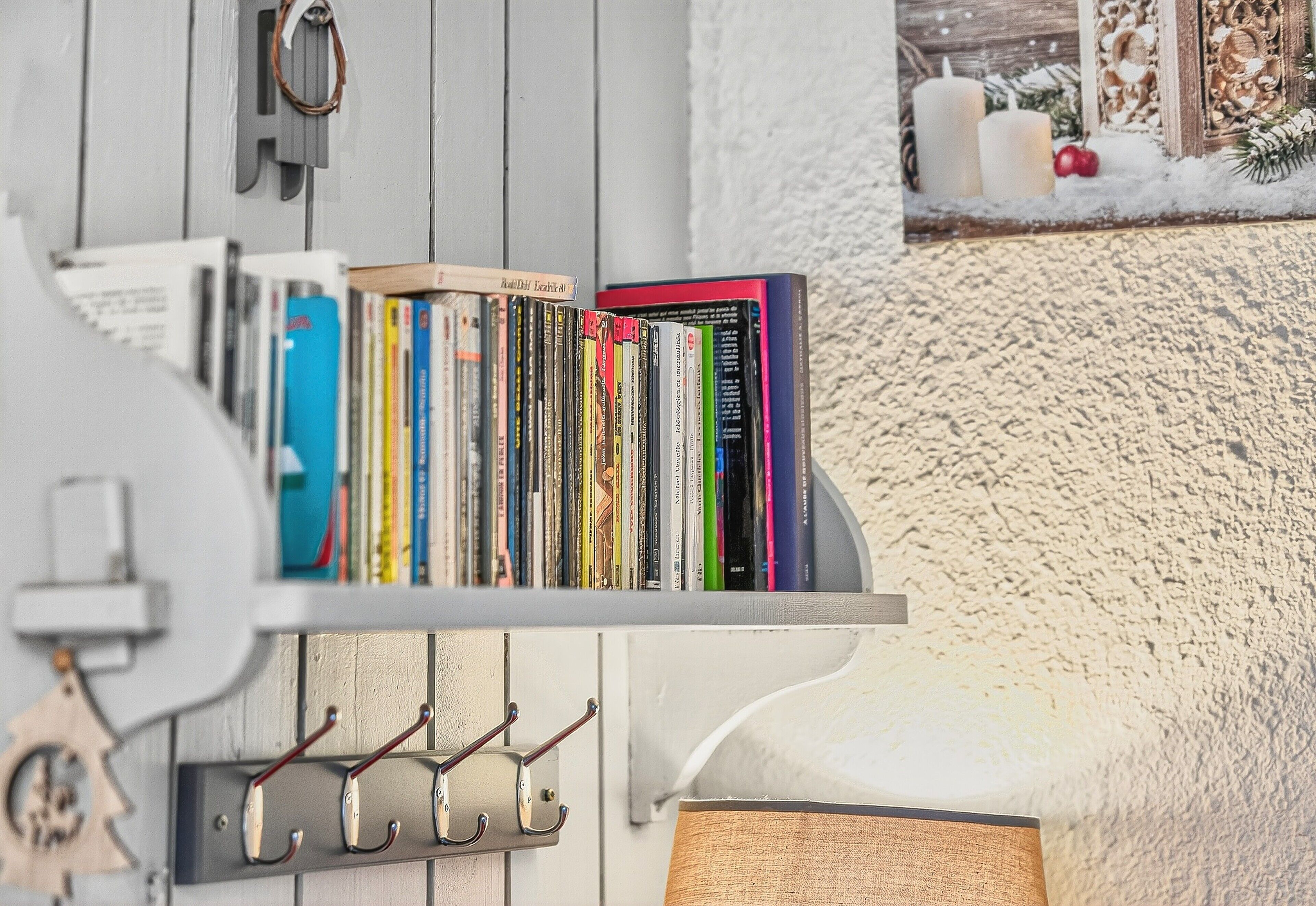 Een boekenplank met boeken en een kapstok.
