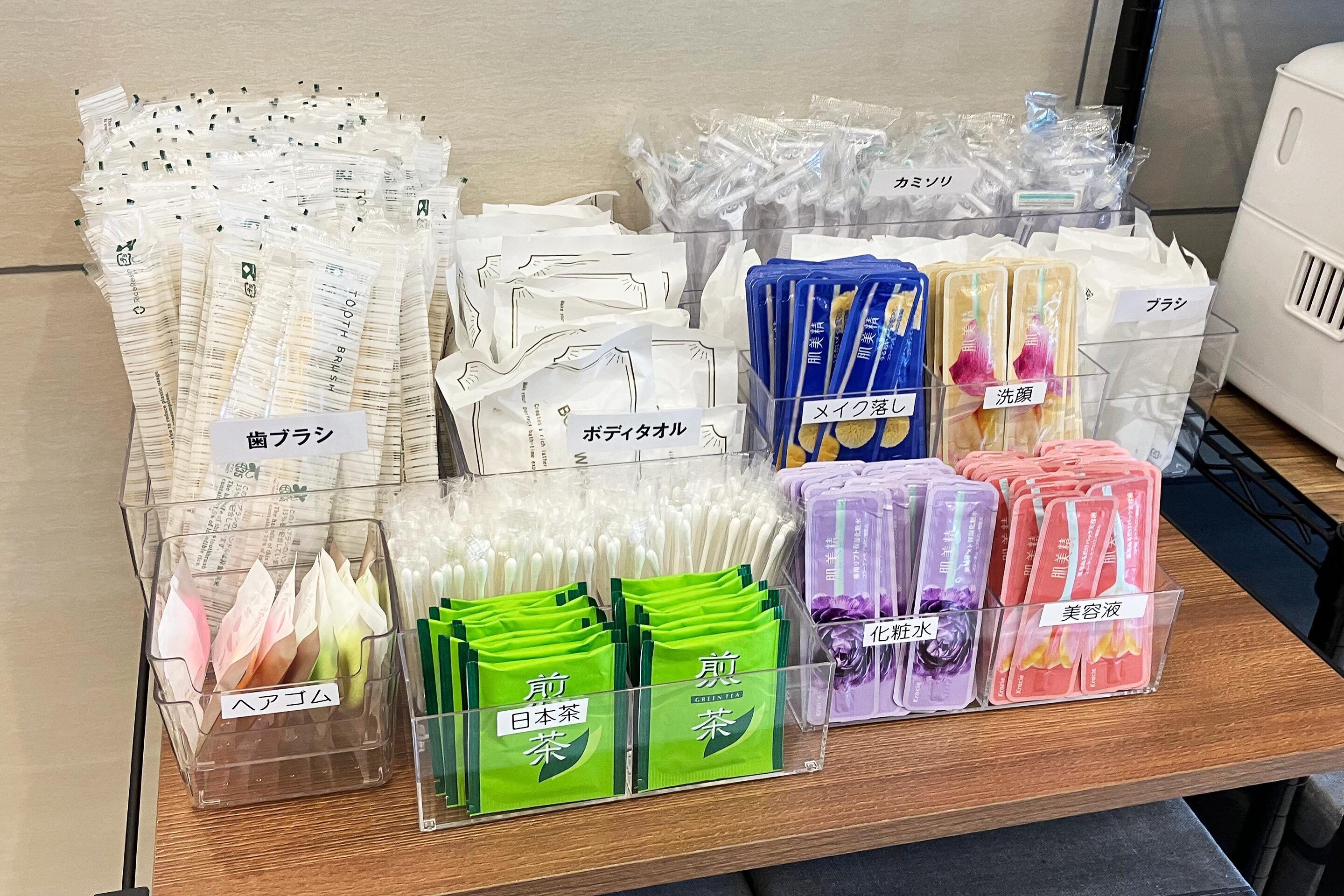 A display of various personal care products, including toothbrushes, toothpaste, and other toiletries, organized in clear plastic bins.