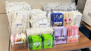 A display of various personal care products, including toothbrushes, toothpaste, and other toiletries, organized in clear plastic bins.