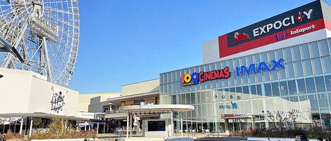 A modern building with a large Ferris wheel in the background, labeled "EXPOCITY" and "100 CINEMAS IMAX".