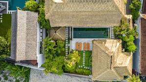 An aerial view of a resort with a swimming pool, lounge chairs, and tropical landscaping. - Villa Gading by Alfred in Bali (Seminyak)