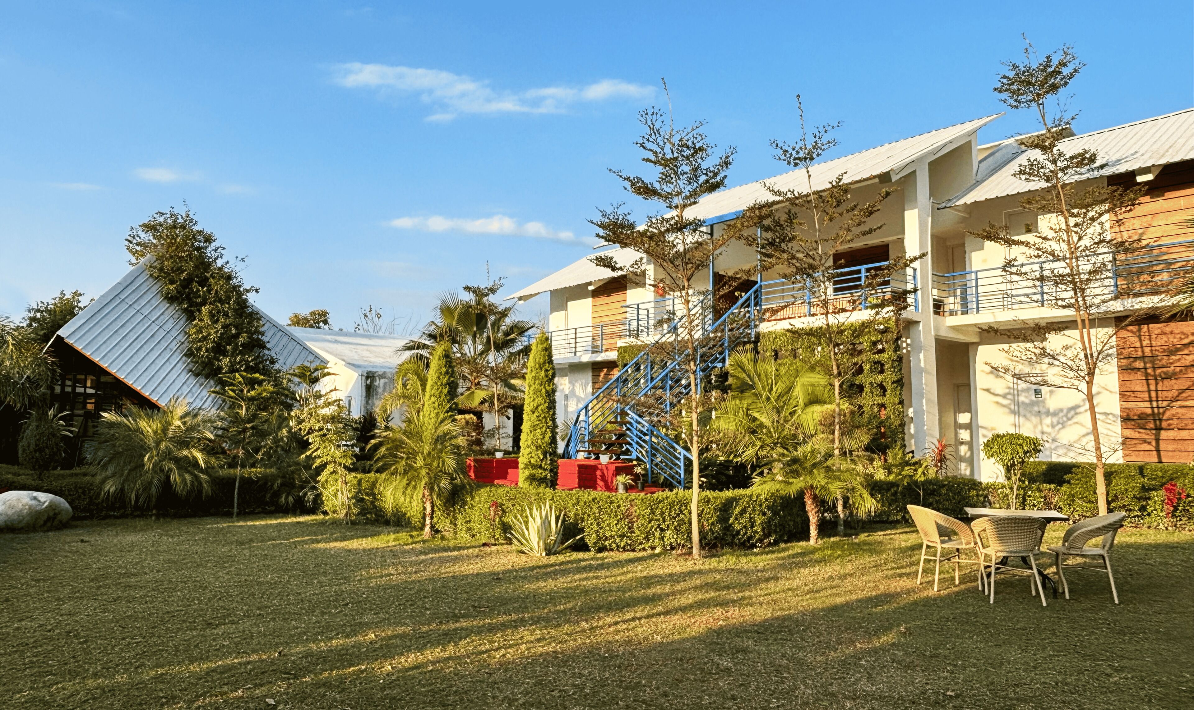 Een hotel met meerdere verdiepingen, terras buiten en een keurig onderhouden tuin.