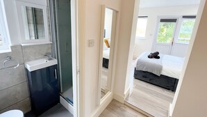 A modern bathroom with a glass shower, a sink, and a toilet. - Minet Gardens Central-Suite 3 (London)