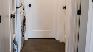 A narrow hallway with a door at the end, a washing machine on the left, and a door on the right. - * * * * *Modern Missoula Bungalow* * * * * (Missoula)