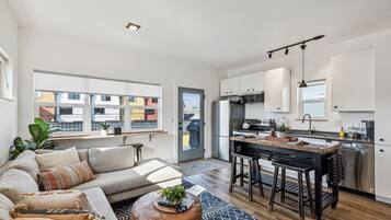 A modern apartment with a living room, kitchen, and dining area.