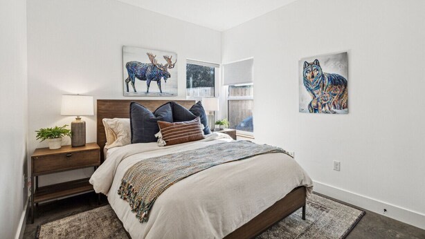 Une chambre à coucher comprenant un lit, une table de chevet, une lampe et des œuvres d’art murales représentant des animaux.