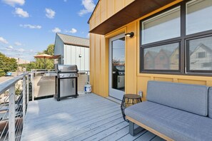 Une terrasse équipée d’un barbecue, d’un canapé et d’une table à manger.
