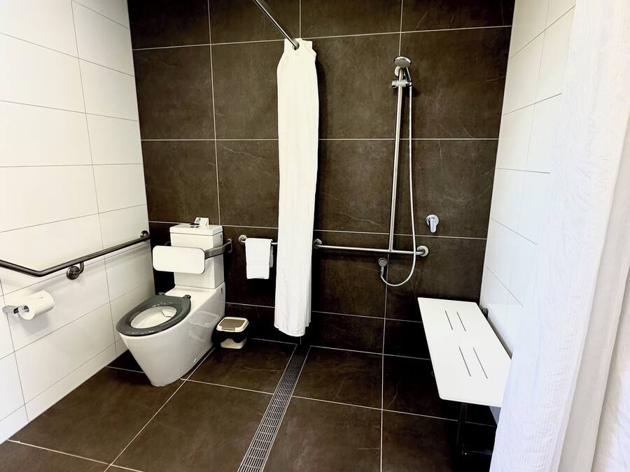 Casa de banho moderna com sanita, bidé e chuveiro.