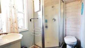 A bathroom with a shower, a sink, and a toilet. - Romantic guest house within walking distance from Lake Texoma. (Pottsboro)