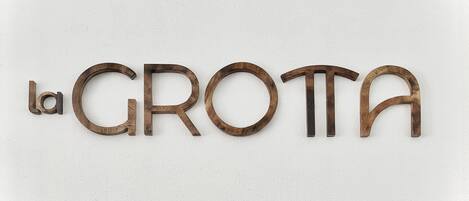 A wall with the text "la GROTA" in wooden letters.