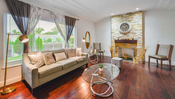 Una sala de estar moderna con un sofá, una mesa de centro de vidrio y una chimenea.