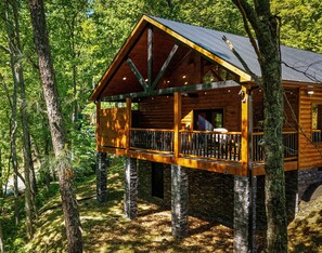 A wooden cabin with a balcony, surrounded by trees. - Luxury Mountain Retreat, 1 level cabin,  5 Min to Downtown Gatlinburg (Gatlinburg)