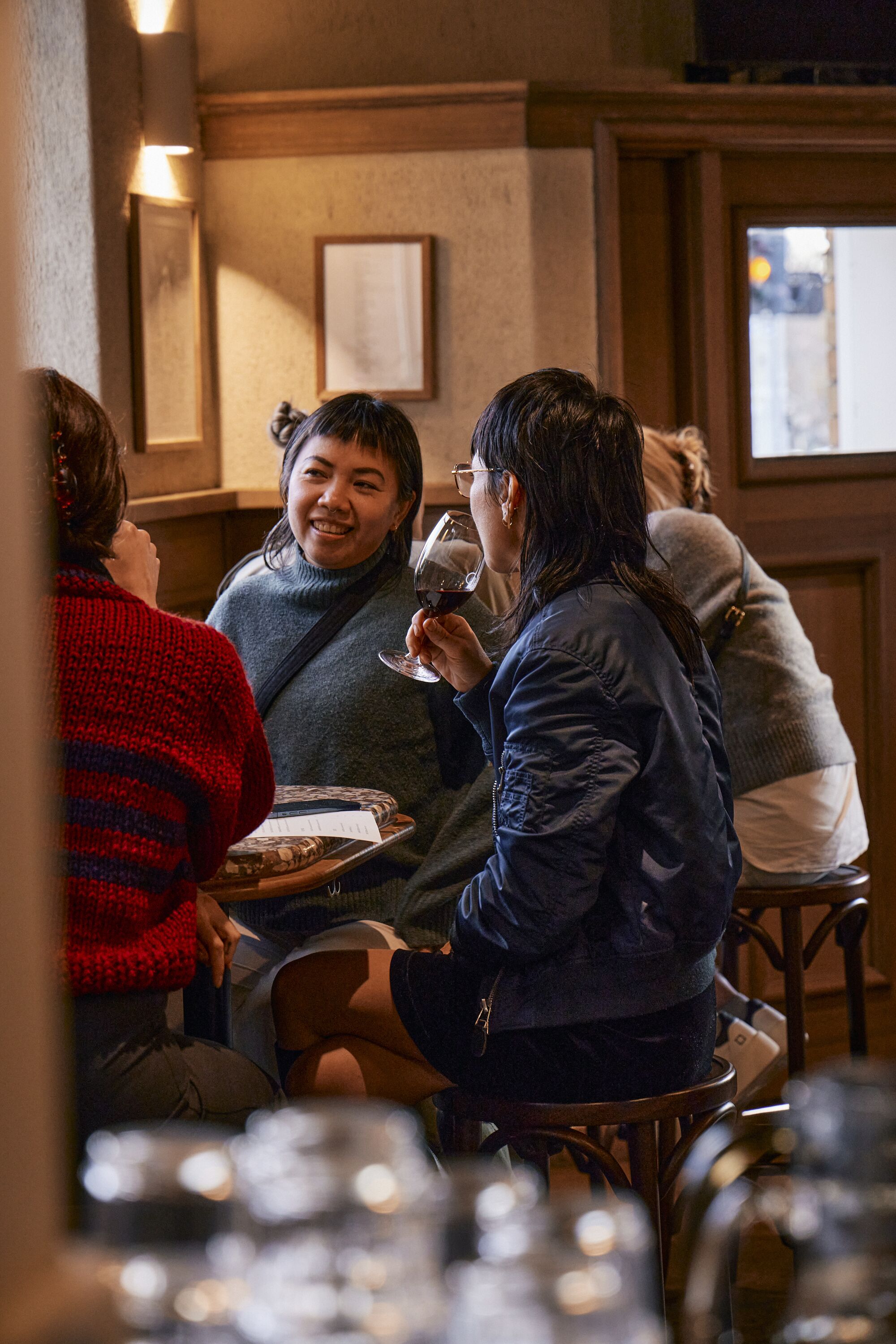 Eine Gruppe von Personen sitzt in einem Restaurant mit Holzeinrichtung und Bildern an der Wand.