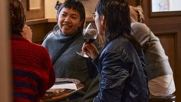 Eine Gruppe von Personen sitzt in einem Restaurant mit Holzeinrichtung und Bildern an der Wand.