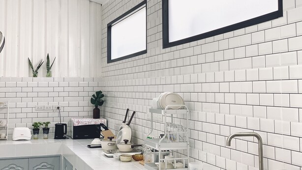 Una cucina moderna con piastrelle bianche a metro, un lavello in acciaio inossidabile e un forno integrato.