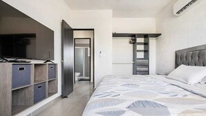 A bedroom with a bed, a wardrobe, and a television.