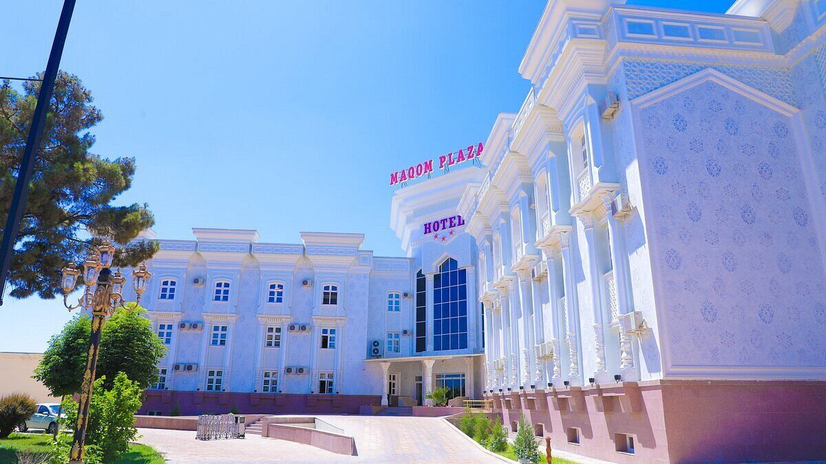 A large, white building with a sign reading "Naoum Plaza Hotel."