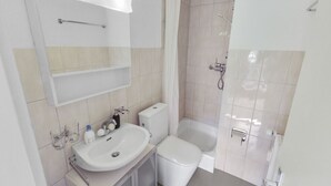 A modern bathroom with a sink, toilet, and shower area. - Elegant studio in the heart of Crans (Crans-Montana)