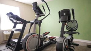 Two stationary bikes in a room with a green wall and a window. - Hotel room with ONE KING BED (Yuma)
