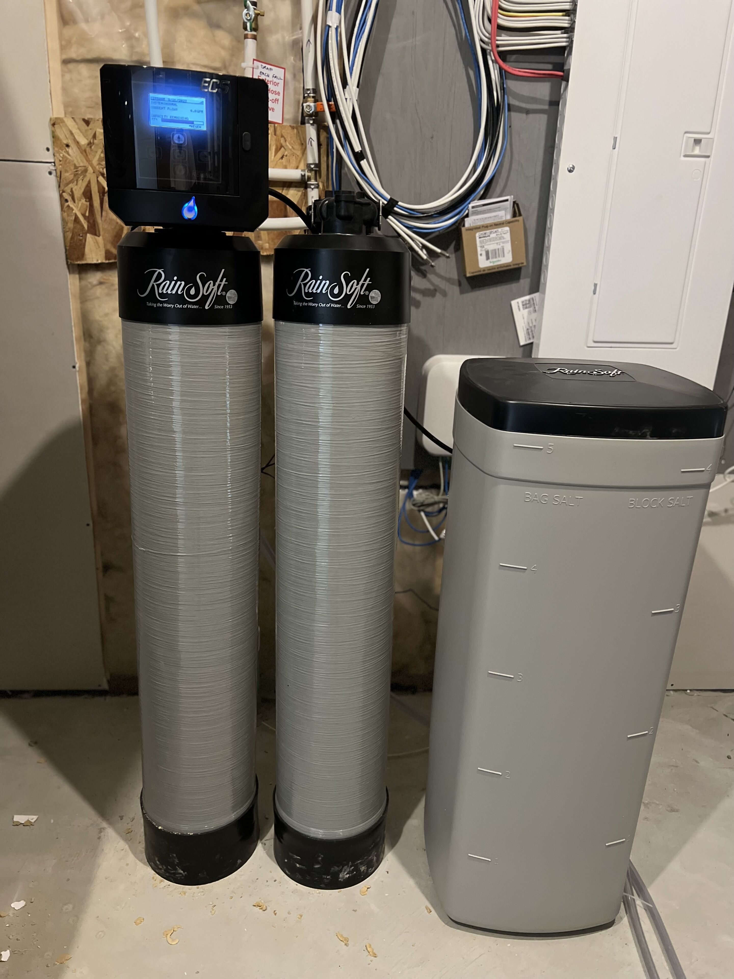 Two large water softeners with a control panel and a salt storage unit.