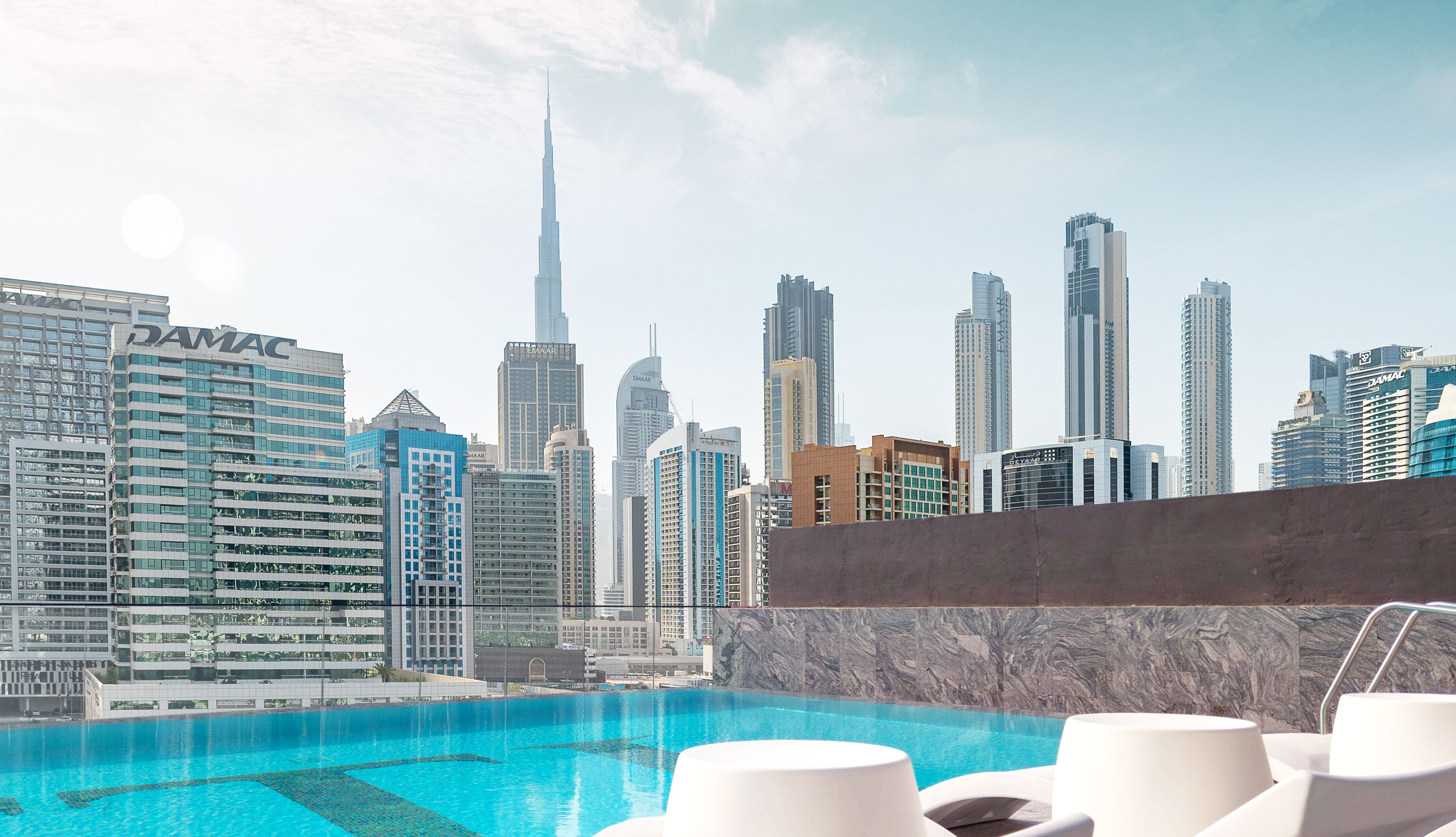 Piscina en la azotea con vista al horizonte de la ciudad, incluyendo el Burj Khalifa.