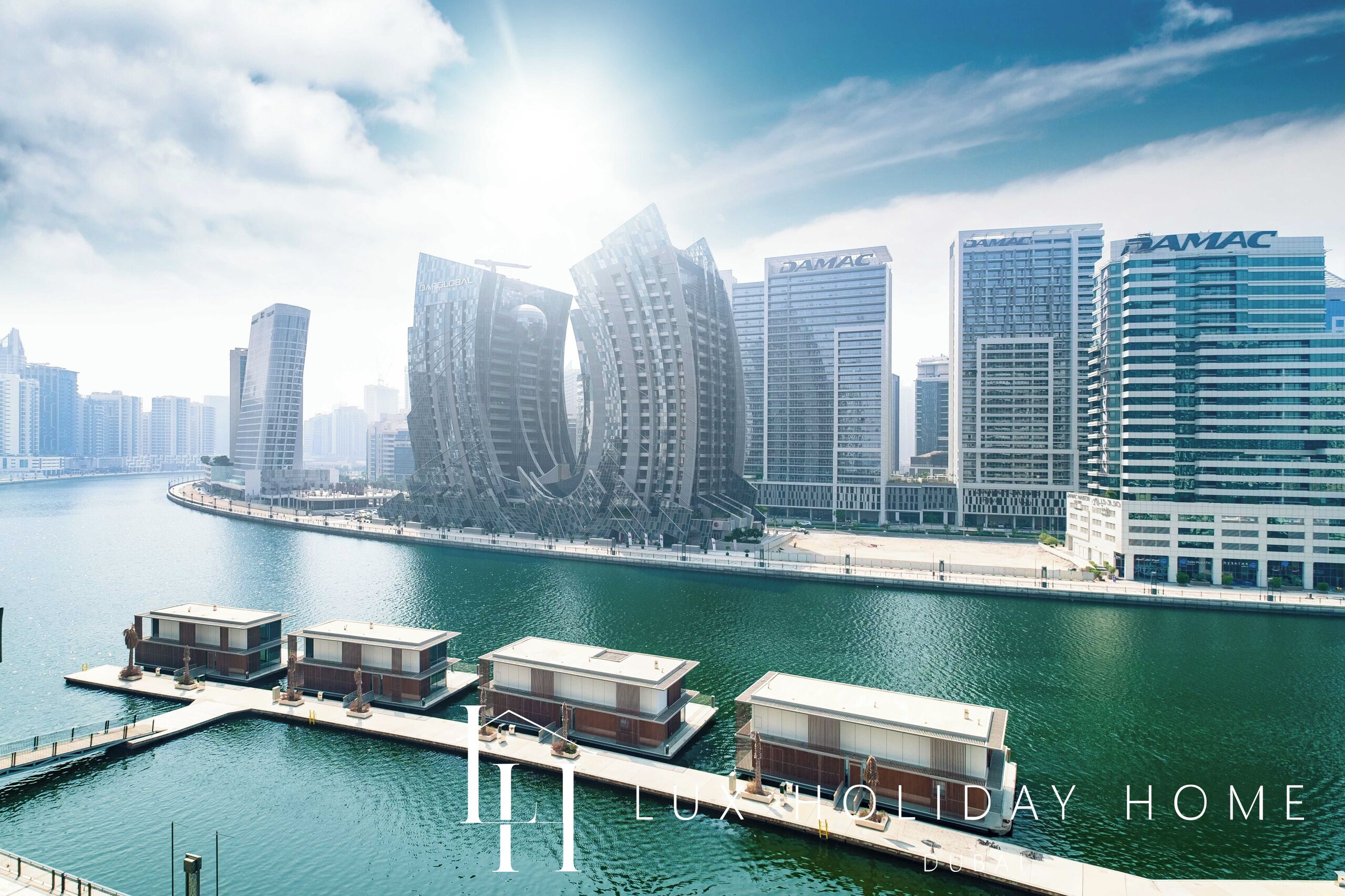 A waterfront property with modern architecture, including a marina and a city skyline in the background.