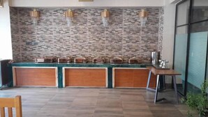 A modern kitchen with a stone backsplash, wooden cabinets, and a glass partition.