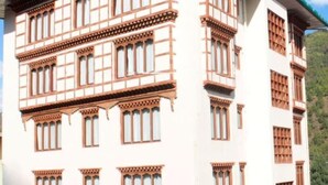 A multi-story building with a traditional architectural style, featuring a series of windows with wooden frames and decorative elements.