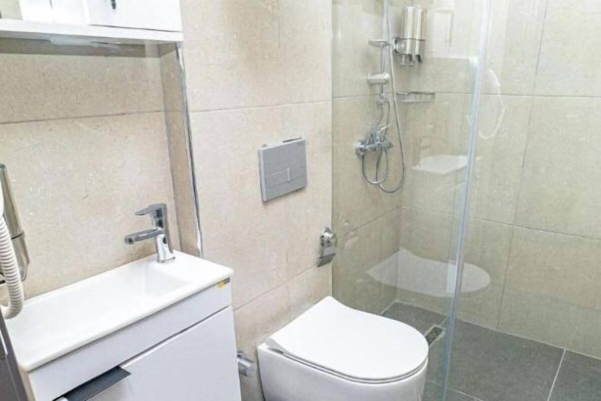 Secador de pelo, pantuflas, piso con calefacción en el baño, toallas