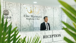 A reception area with a marble wall, a clock, and a sign for 'Elite Marmara Bosphorus & Otel'. - Elite Marmara Bosphorus Çamlıca (Istanbul)