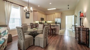 Una cocina amplia con armarios de madera, una isla central y una zona de comedor con cuatro sillas.