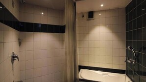 Et moderne badeværelse med bruser, badekar og fliserede vægge.