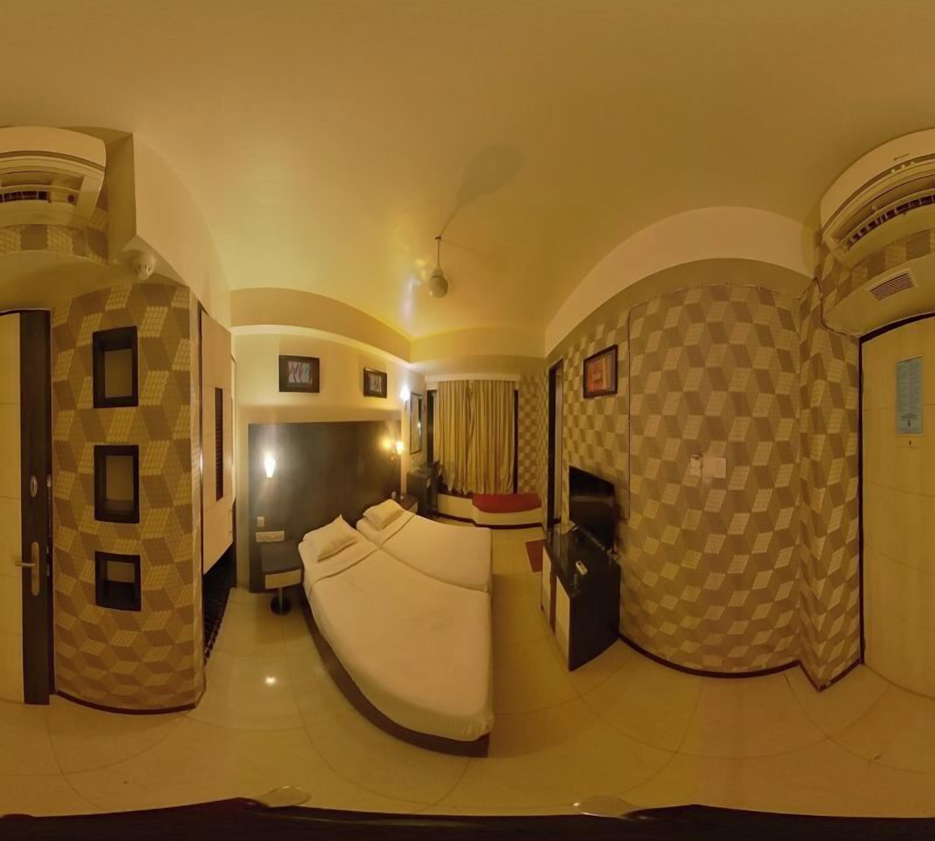 A room with a curved bed, a desk, and a wardrobe.