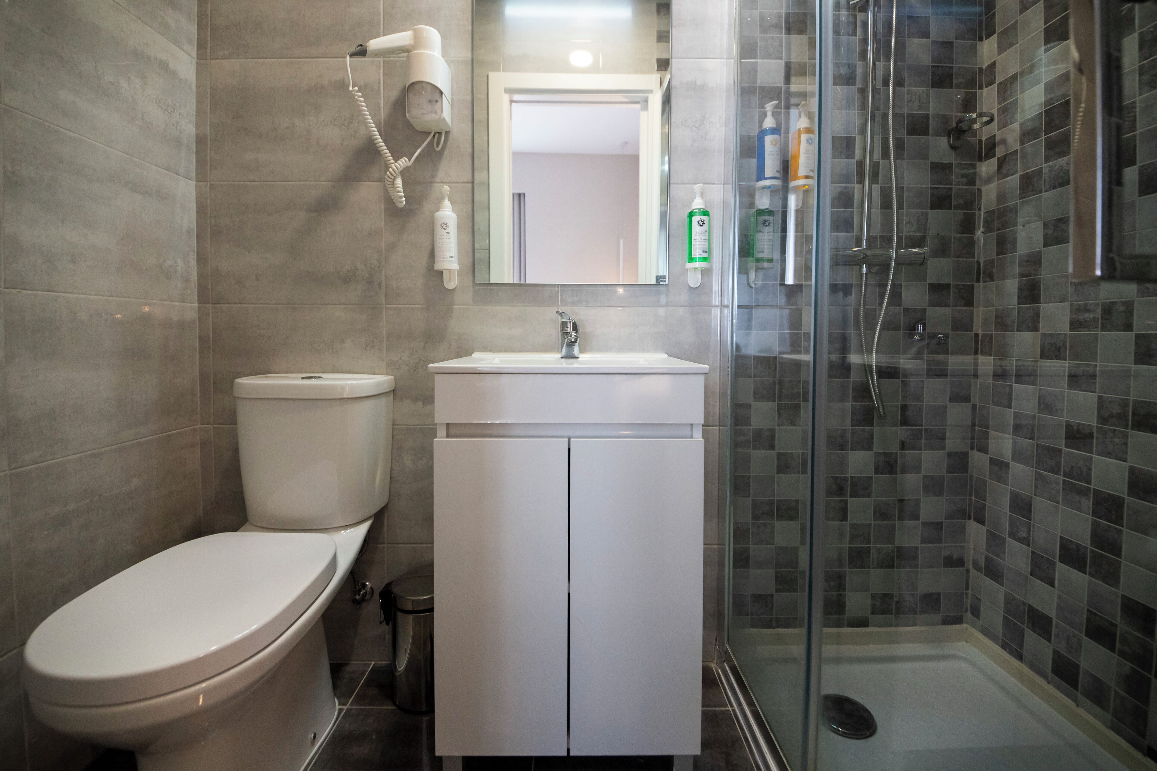 A bathroom with a toilet, sink, and shower.