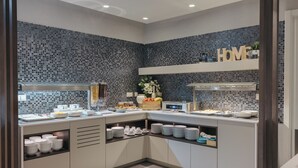 A modern kitchen with a blue mosaic backsplash, white cabinets, and a breakfast bar. - M’AR De AR Auria (Lisbon)